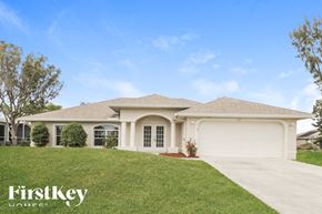 Cape Coral house for rent - the exterior of a house with a driveway and grass