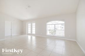 Cape Coral house for rent - an empty living room with a large window and tiled floors