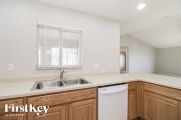 Cape Coral house for rent - a kitchen with a sink and a dishwasher and wooden cabinets