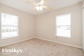 Cape Coral house for rent - a bedroom with a ceiling fan and two windows
