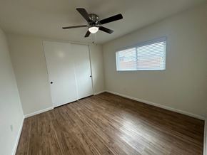 Whittier apartment for rent - A room with a ceiling fan and a window with blinds.
