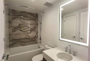 Vancouver apartment for rent - A bathroom with a stone wall and a white toilet.