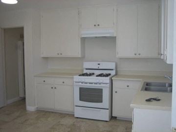 Covina apartment for rent - A white kitchen with a stove and cabinets.