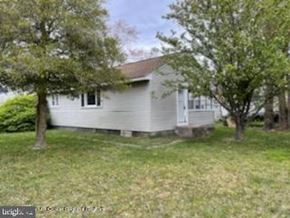 Ocean Township house for rent - A house with a white siding and a grey roof is surrounded by trees.