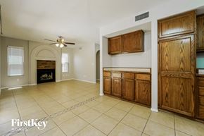 Tucson house for rent - a kitchen and living room with a fireplace and wooden cabinets