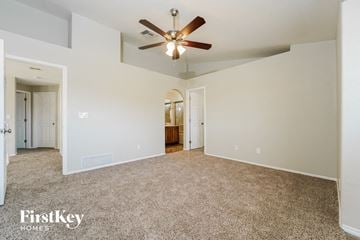 Tucson house for rent - a spacious living room with a ceiling fan and carpet