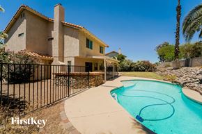 Tucson house for rent - a pool in front of a house with a wrought iron fence