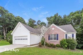 Dacula house for rent - A house with a white garage and a brick house with blue windows.