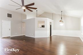 Dacula house for rent - A spacious room with a ceiling fan and wooden flooring.