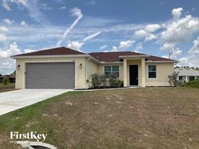 Lehigh Acres house for rent - a house with a driveway and a garage door