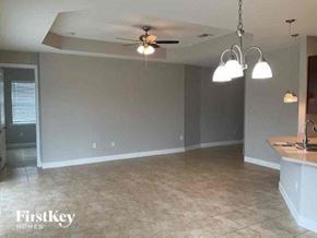 Lehigh Acres house for rent - an empty living room with a ceiling fan