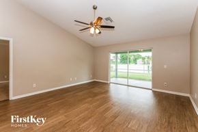 Cape Coral house for rent - an empty living room with wood flooring and a ceiling fan
