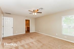 Cape Coral house for rent - a living room with a ceiling fan and a door to a bathroom