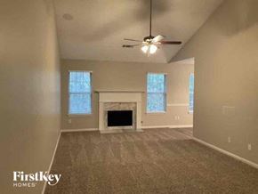 Sugar Hill house for rent - an empty living room with a ceiling fan and a fireplace