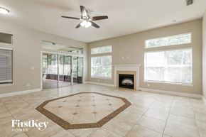 Jacksonville house for rent - an empty living room with a fireplace and a ceiling fan