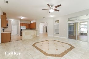 Jacksonville house for rent - an open kitchen and living room with tile flooring and a ceiling fan