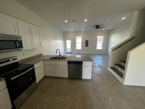 Youngsville apartment for rent - a kitchen with white cabinets and a black stove and a sink