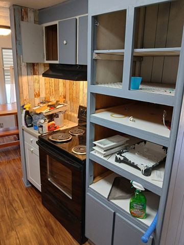 Boise house for rent - A kitchen with a black stove top oven and a wooden floor.