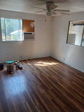 Boise house for rent - A room with a ceiling fan and a window with a view of a pool and trees.