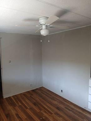 Boise house for rent - A room with a ceiling fan and wood flooring.