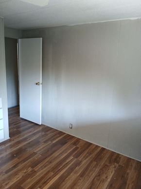 Boise house for rent - A room with a white door and wooden floors.