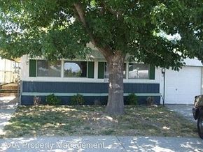 Boise house for rent - A tree in front of a green and white building.