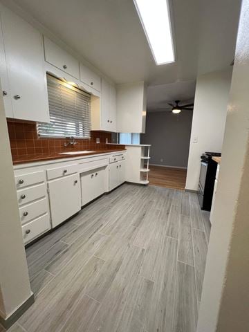 Fullerton apartment for rent - A kitchen with white cabinets and a grey floor.