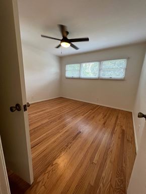 Fullerton apartment for rent - A room with a ceiling fan and wooden flooring.
