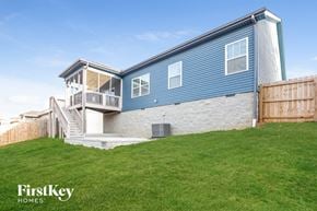 Clarksville house for rent - the exterior of a blue house with a lawn and a deck