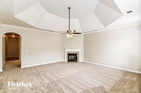 Gardendale house for rent - A spacious room with a fireplace and a ceiling fan.