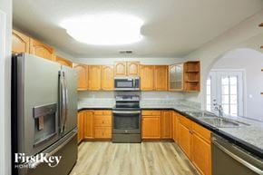 Phoenix house for rent - a kitchen with wooden cabinets and stainless steel appliances