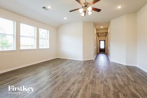 Splendora house for rent - A spacious room with wooden flooring and a ceiling fan.