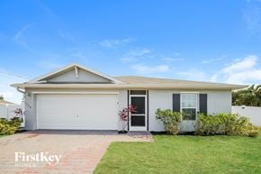 Cape Coral house for rent - a white house with a lawn and a blue sky