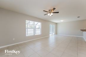Cape Coral house for rent - a clean and empty living room with a ceiling fan