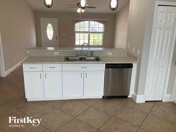 Cape Coral house for rent - a kitchen with white cabinets and a sink and a dishwasher