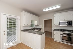 Acworth house for rent - a kitchen with white cabinets and a counter top