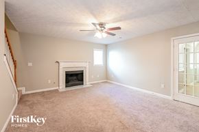 Lilburn house for rent - A room with a fireplace and a ceiling fan.