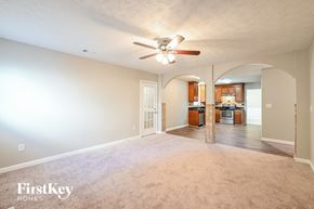 Lilburn house for rent - A spacious living room with a ceiling fan and a view of the kitchen.