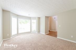 Lilburn house for rent - A spacious room with a carpeted floor and a doorway leading to another room.