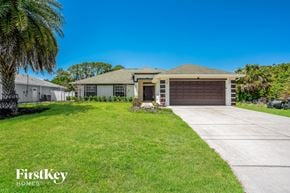 North Port house for rent - a house with a driveway and a palm tree