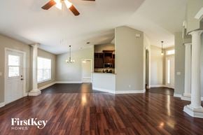 North Port house for rent - an empty living room with wood flooring and a kitchen