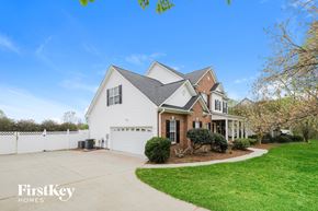 Advance house for rent - a white house with a driveway and a white fence