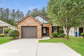 Kimberly house for rent - A brick house with a garage door and a tree in front.