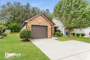 Kimberly house for rent - A brick house with a garage door and a tree in front.