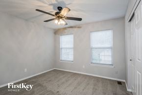 Ballwin house for rent - a bedroom with two windows and a ceiling fan