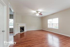 Monroe house for rent - an empty living room with a ceiling fan and a fireplace