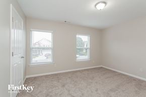 Monroe house for rent - an empty bedroom with two windows and a door