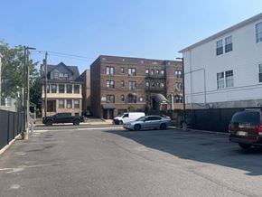 Irvington apartment for rent - A parking lot with cars and buildings in the background.