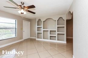 Lehigh Acres house for rent - a dining room with white shelves and a ceiling fan