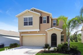 Wimauma house for rent - a beige house with a palm tree in front of it